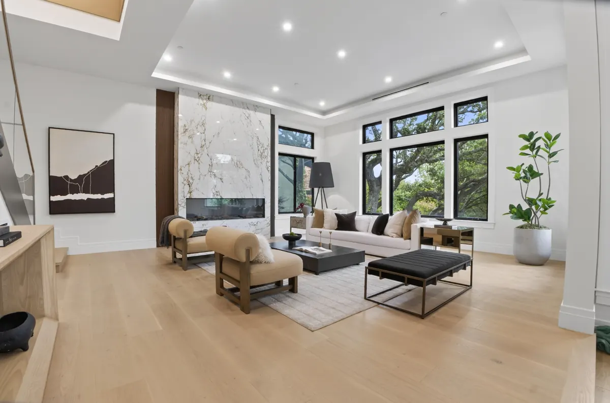 Great room with a marble fireplace wall and sculptural lounge chairs