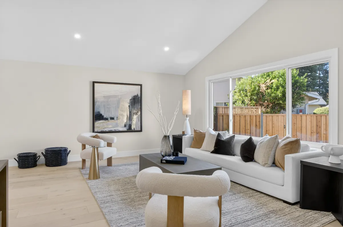 Vaulted living room with a wall of glass to the backyard